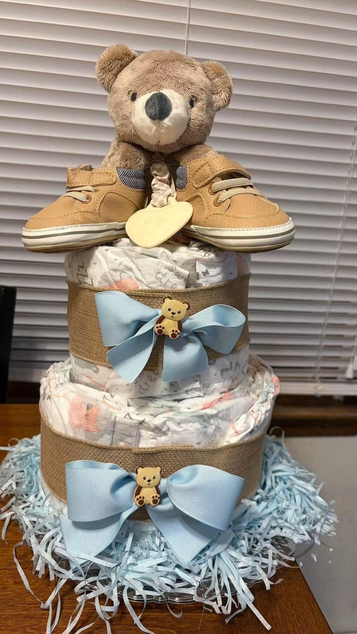 A handmade teddy bear themed diaper cake with blue bows
